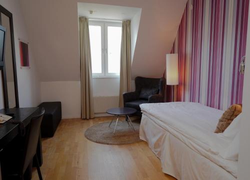 a hotel room with a bed and a chair at Best Western Plus JA Hotel Karlskrona in Karlskrona