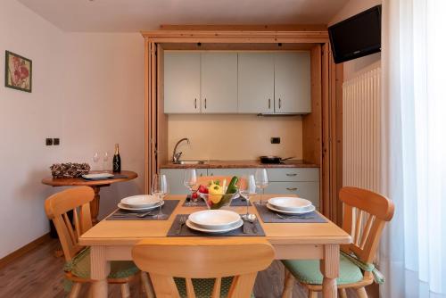 a dining room table with chairs and a kitchen at Hotel Castel Pietra in Fiera di Primiero