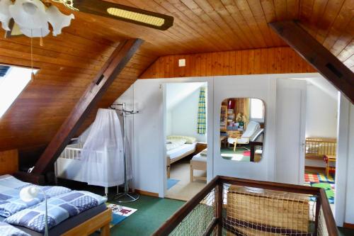 a attic bedroom with a bed and a living room at Guntli’s family Guesthouse in Andelfingen