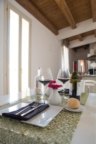 a table with two glasses and a bottle of wine at Hotel Ristorante Ala d'Oro in Lugo