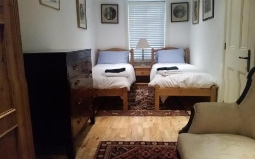 a living room with two beds and a couch at Old School Apartment 2 Ground Floor in Bury Saint Edmunds