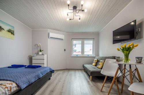 1 dormitorio con cama, sofá y mesa en Pilkoji kopa, en Nida