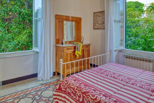 una camera con un letto e un lavandino e due finestre di Leone I and Leone II Apartments a Levanto