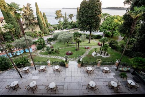 - une vue aérienne sur un parc avec des tables et des chaises dans l'établissement Hotel Bellevue, à Gardone Riviera