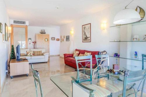 a living room with a red couch and a glass table at Divine Vilamoura Aquamar 106 by JG Apartments in Vilamoura