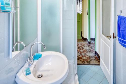 un bagno con un lavandino bianco e uno specchio di Leone I and Leone II Apartments a Levanto