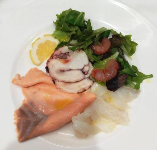 a white plate of food with fish and vegetables at Grand Hotel Cesare Augusto in Sorrento