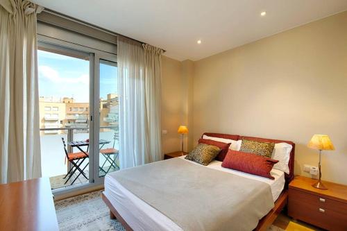 a bedroom with a large bed and a balcony at Great and Seaside Flat in Barcelona