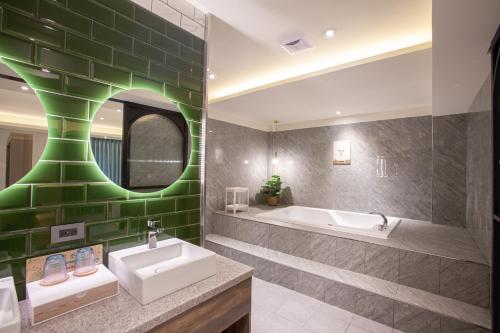 a bathroom with a sink and a tub and a mirror at 里萊行旅 - Lilai Motel in Taoyuan