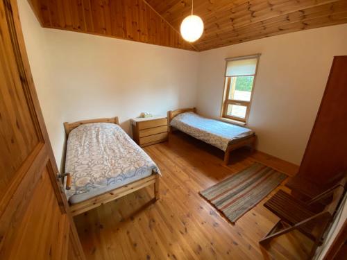 Habitación pequeña con 2 camas y ventana en Kasteheina kodu en Voka