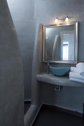 a bathroom with a sink and a mirror and towels at Aroma Suites in Fira