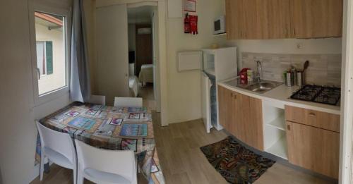 a small kitchen with a table and a counter top at Camping Al Lago Ledro in Ledro