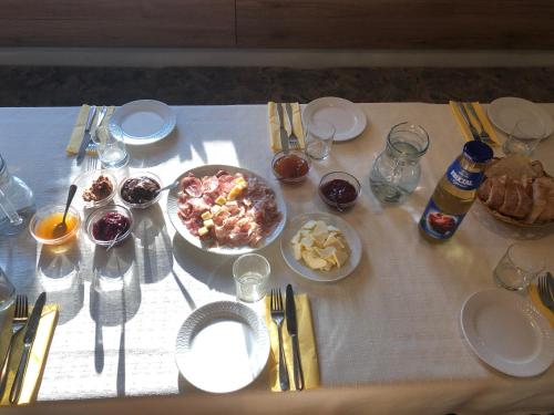 una mesa cubierta con una mesa con comida y bebida en Wooden Cabin Zurej with Hot Tub, en Bukovje v Babni Gori