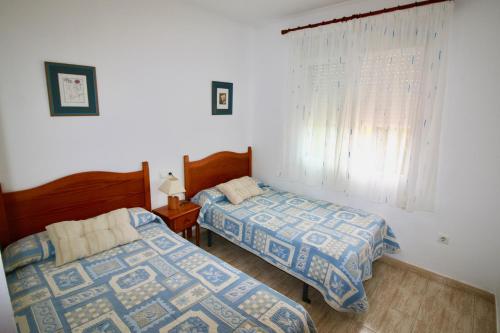 デニアにあるResidencial Datiler El Retiroのベッドルーム1室(ベッド2台、窓付)