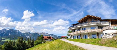 a house on a hill with mountains in the background at Bucheggerhof in Schladming
