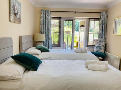 three beds in a room with windows and a room at The Garden Suite in Basingstoke