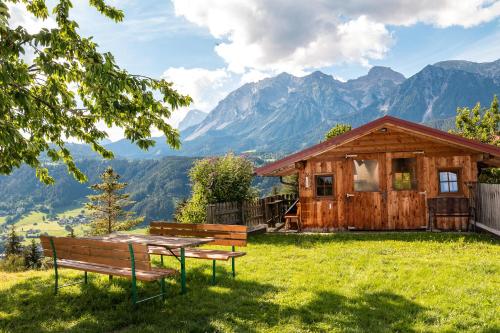 a cabin in the mountains with a table and benches at Bucheggerhof in Schladming