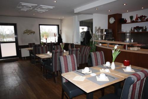 Hotel Haus Berger في كولونيا: غرفة طعام مع طاولات وكراسي خشبية