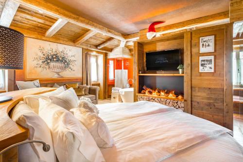 um quarto com uma cama grande e uma lareira em John Luxury Suites em Folgaria