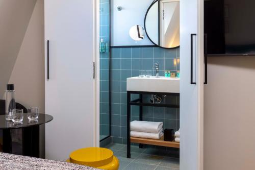 a bathroom with a sink and a mirror at Hotel Le 37 Bis in Neuilly-sur-Seine