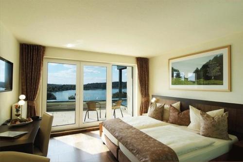 a hotel room with a bed and a balcony at Hochwälder Wohlfühlhotel in Losheim