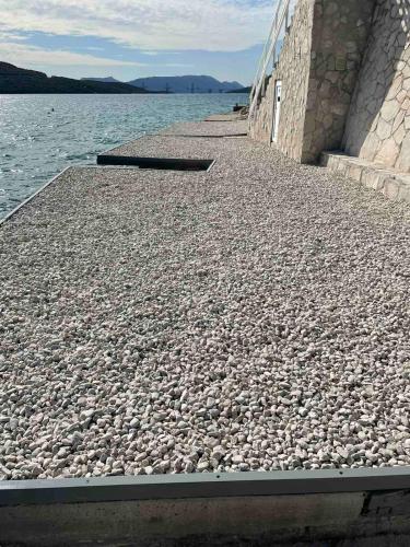 a stone walkway next to a body of water at Apartments Lukrecia in Neum