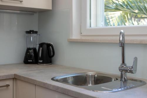 a kitchen counter with a sink and a window at APARTMENTS BAKA in Selca