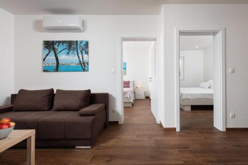 ein Wohnzimmer mit Sofa und ein Schlafzimmer in der Unterkunft APARTMENTS BAKA in Selca