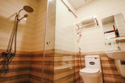 a bathroom with a shower and a toilet and a sink at Hotel Phương Anh in Phù Cát