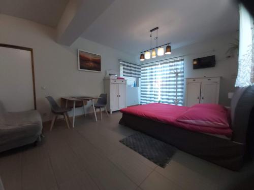 ブワディスワボボにあるLa Villa Alexandre - PARTERのベッドルーム(赤いベッド1台、テーブル付)