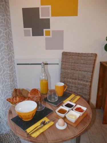 a table with breakfast foods and orange juice on it at Opale des Caps in Leubringhen