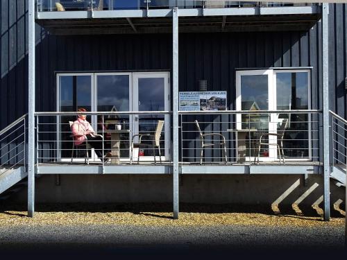 a person sitting on a balcony of a building at Bogense Feriebo in Bogense