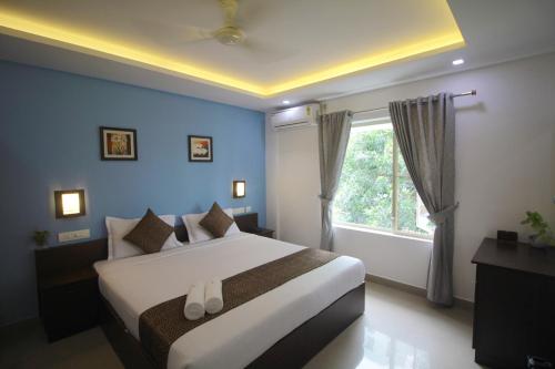 a bedroom with a large bed and a window at North Centre in Cochin