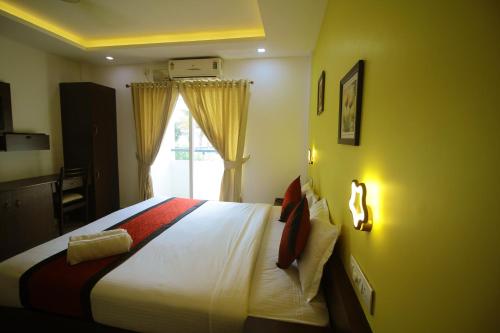 a bedroom with a bed and a window at North Centre in Cochin