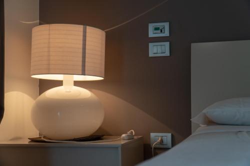 a lamp on a table next to a bed at Magrine Castelfranco Veneto in Castelfranco Veneto