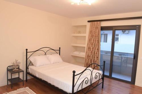 a bedroom with a bed and a glass door at Dr Vasi Holidays House in Agios Nikolaos