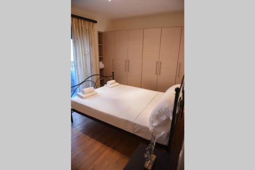 a bedroom with a bed with white sheets at Dr Vasi Holidays House in Agios Nikolaos