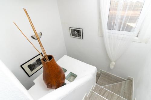 un vase assis sur un canapé blanc dans une pièce dans l'établissement Casa Salinas del Mar, à Guatiza