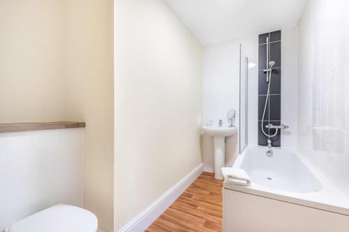 a white bathroom with a tub and a sink at Bridge House in Totnes