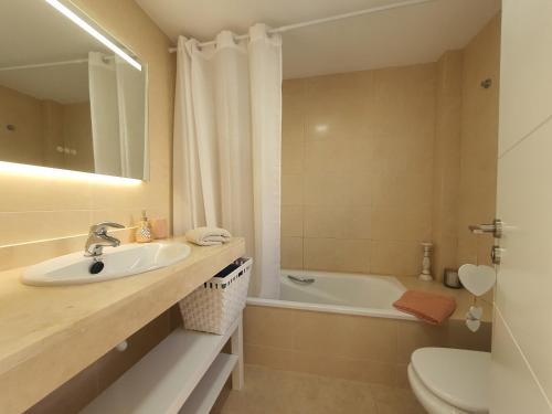 La salle de bains est pourvue d'un lavabo, de toilettes et d'une baignoire. dans l'établissement Los Gigantes Ocean View Apartment, à Puerto de Santiago