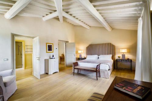 a large bedroom with a bed and a couch at La Pietra Del Cabreo in Greve in Chianti