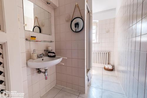 uma casa de banho branca com um lavatório e um espelho em Apartament 27 z tarasem em Jelenia Góra