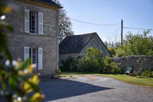 una casa de piedra con un banco delante en Utah Beach Chambre hote, en Sainte-Marie-du-Mont