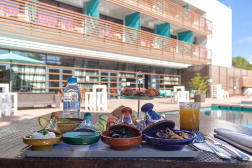 a tray with bowls of food on a table near a pool at Hôtel Souani ( Al Hoceima Bay) in Al Hoceïma