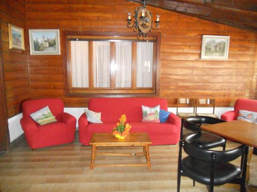 a living room with a red couch and a table at Mondo D'Oro in Macugnaga