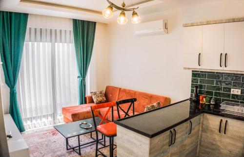 a kitchen and living room with a table and chairs at Orion Apart Tekirova in Kemer