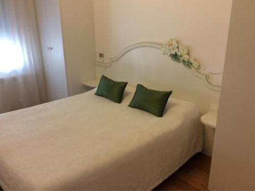a bedroom with a bed with two green pillows at Locanda Mezzosale in Conegliano