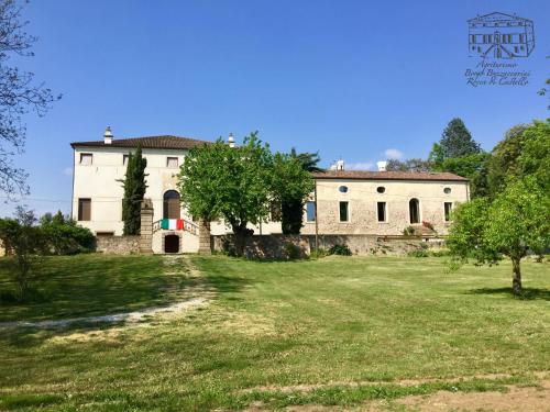 una casa vieja con un patio de hierba delante de ella en Agriturismo Borgo Buzzaccarini Rocca di Castello en Monselice