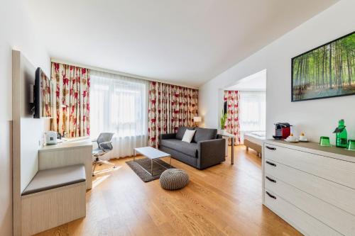 a living room with a couch and a tv at Hotel Zeitgeist Vienna Hauptbahnhof in Vienna