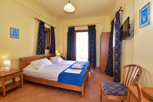 a bedroom with a bed and a chair and a window at Galissas Studios in Galissas